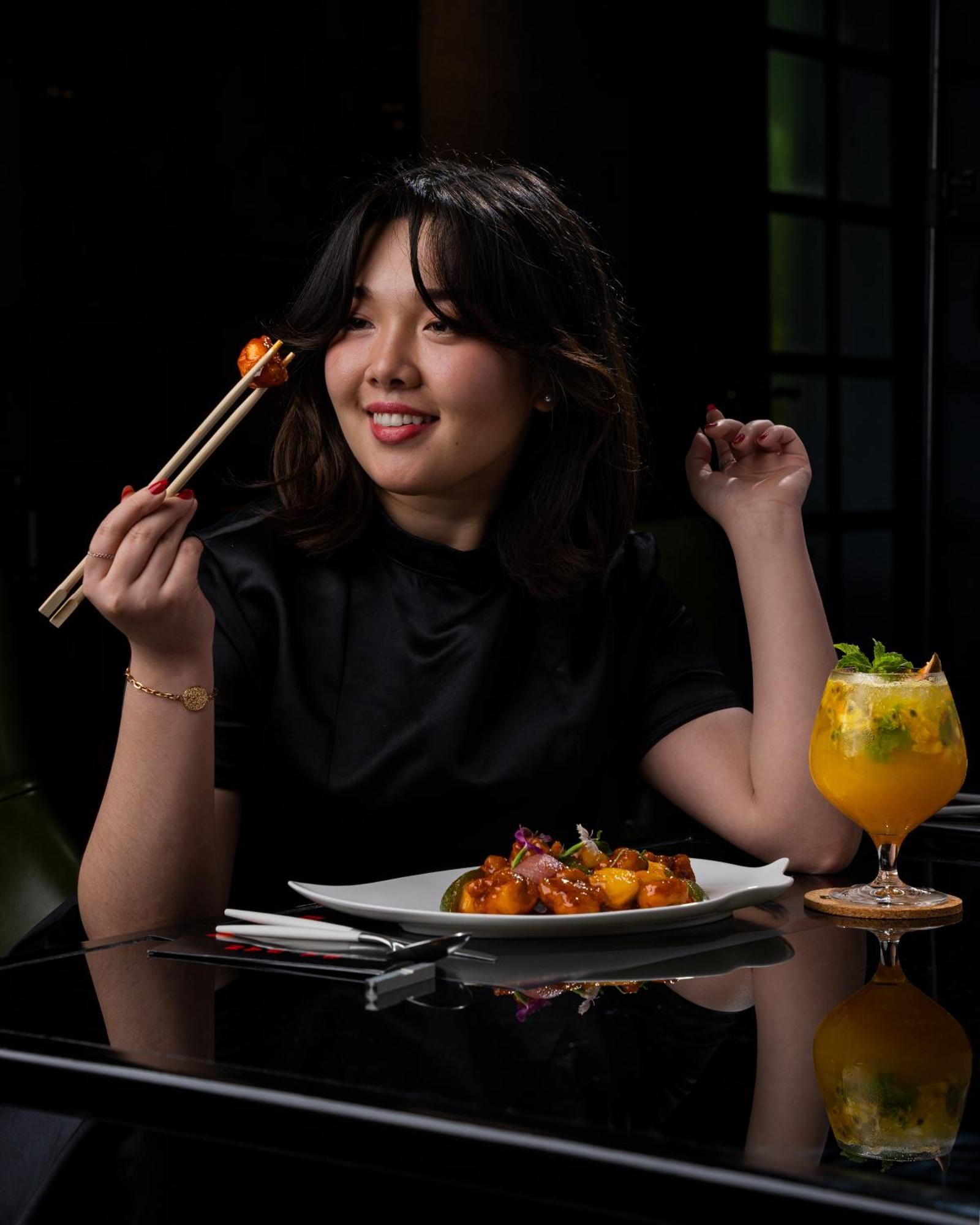 W Muscat Hotel Ngoại thất bức ảnh A woman eating with chopsticks